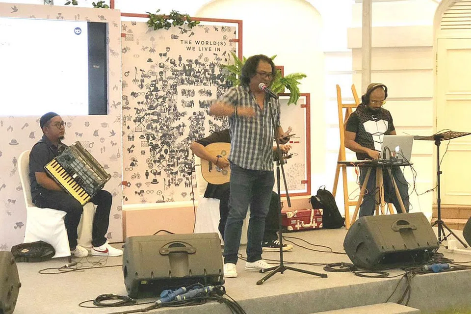 PENUH AKSI: Rafaat Hamzah (tengah) mendeklamasikan beberapa kuntum puisi yang dipetik daripada buku 'Prasasti Cinta', diiringi pemuzik di acara pelancaran buku puisi itu yang berlangsung di Art House sempena Pesta Penulis Singapura (SWF) 2018. - Foto ihsan RAFAAT HAMZAH