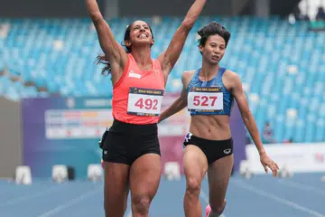 TERUSKAN MOMENTUM: Shanti Pereira (kiri) selepas melangkah garisan penamat di peringkat akhir acara 100 meter Sukan SEA Kemboja.