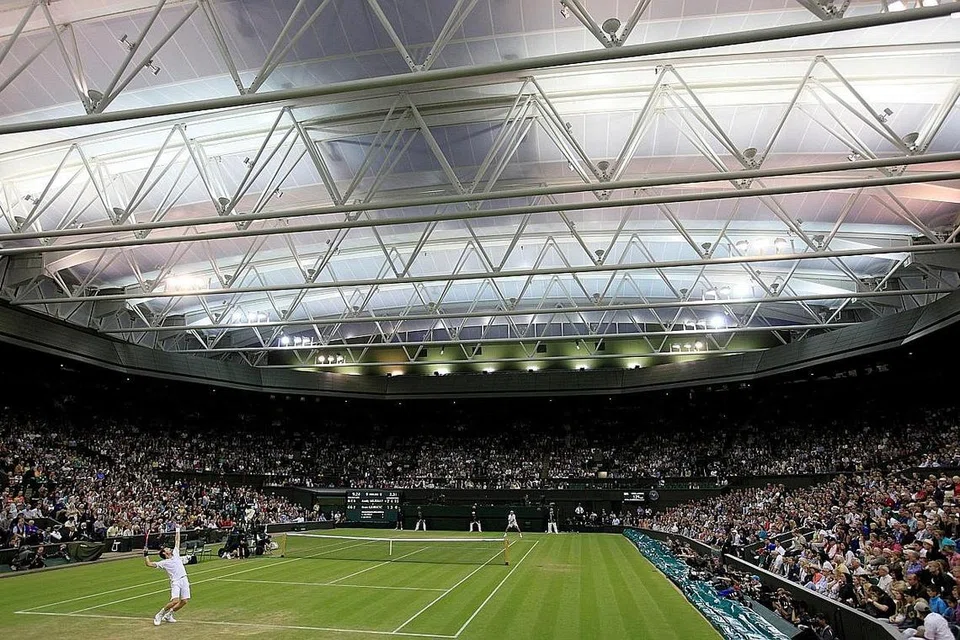 SAMBIL SELAM, MINUM AIR: Pelajar NYP, Cik Khoo dan Cik Lim bersama pensyarah Encik Azhar bergambar di hadapan stadium berlangsungnya Kejohanan Wimbledon (gambar atas). Selain menyelesaikan projek industri politeknik itu, kededua pelajar itu ghairah dapat bertemu dengan beberapa bintang tenis dunia dengan lebih dekat lagi. - Foto REUTERS