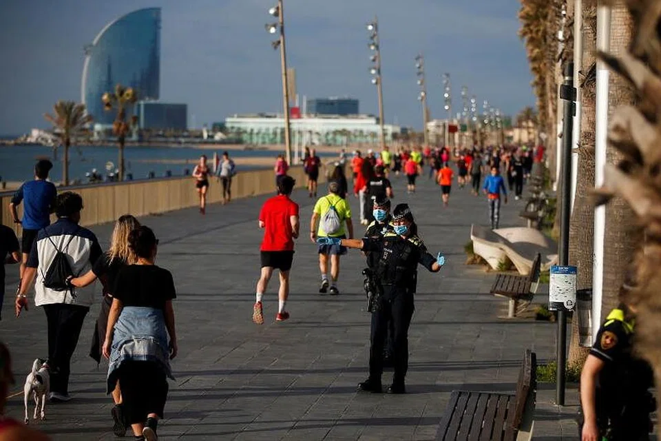 KAMI BEBAS!: Kerajaan Sepanyol membenarkan warga dewasa untuk keluar bersenam, tujuh minggu selepas terperap di rumah kerana mematuhi arahan perintah berkurung yang dikuatkuasakan. Kelihatan anggota polis (kanan) membantu mengingatkan pejalan kaki mengekalkan jarak selamat semasa menikmati pagi mereka di persiaran Paseo Maritimo, Barcelona, yang dirakamkan awal pagi ini. 