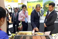 MELAYAN PENIAGA ANTARABANGSA: Encik Azhar (kanan) melayan peniaga Arab di gerainya ketika menyertai GulFood di Dubai. - Foto ihsan AZHAR SULAIMAN