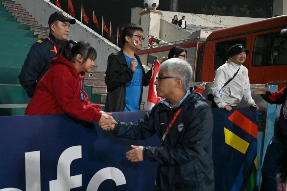 Jurulatih skuad bola sepak Singapura, Tsutomu Ogura (kanan), beri penghargaan kepada penyokong Singapura di Vietnam.