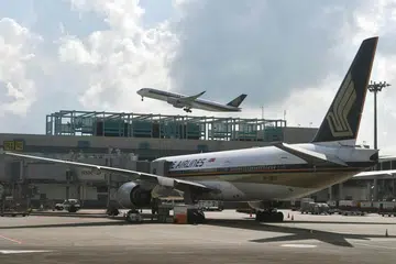 WANITA DAN ANAK DISOAL: Pesawat SQ423 yang membawa 263 penumpang dari Mumbai ke Singapura selamat mendarat dengan iringan pesawat pejuang Angkatan Udara Republik Singapura (RSAF) di Lapangan Terbang Changi sekitar 8 pagi semalam. - Foto fail 