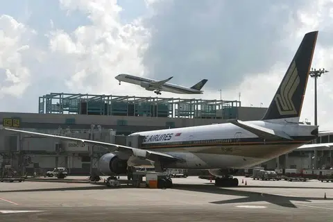 WANITA DAN ANAK DISOAL: Pesawat SQ423 yang membawa 263 penumpang dari Mumbai ke Singapura selamat mendarat dengan iringan pesawat pejuang Angkatan Udara Republik Singapura (RSAF) di Lapangan Terbang Changi sekitar 8 pagi semalam. - Foto fail 
