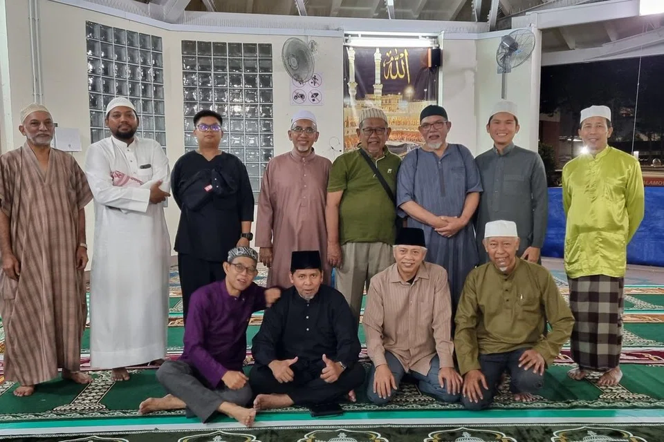 Encik Hamzah Halil (duduk kiri) bersama relawan Qaryah 14 serta penduduk sekitar Woodlands Street 71