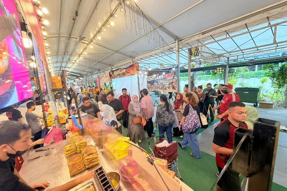 Pelanggan di Singapura beratur untuk mendapatkan martabak jualan peniaga dari Malaysia, Cik Ramlah Ali, di Bazar Ramadan Admiralty, Singapura.  