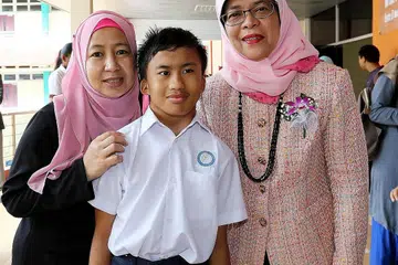 PENERIMA DERMASISWA: Elhann dan ibunya, Cik Suhanah, bergambar dengan tetamu terhormat majlis penyampaian dermasiswa dan biasiswa MDIS, Speaker Parlimen Cik Halimah Yacob (kanan). - Foto SHAHRIYA YAHAYA