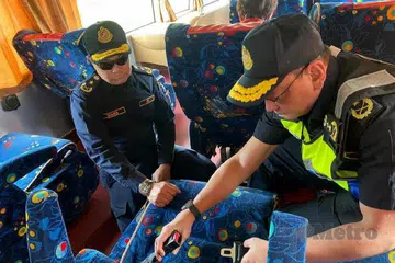 Pengarah JPJ Kedah, Encik Stien Van Lutam (kanan) memeriksa tali pinggang keledar di dalam sebuah bas ekspres yang diperiksa dalam operasi pada 1 Julai 2025.