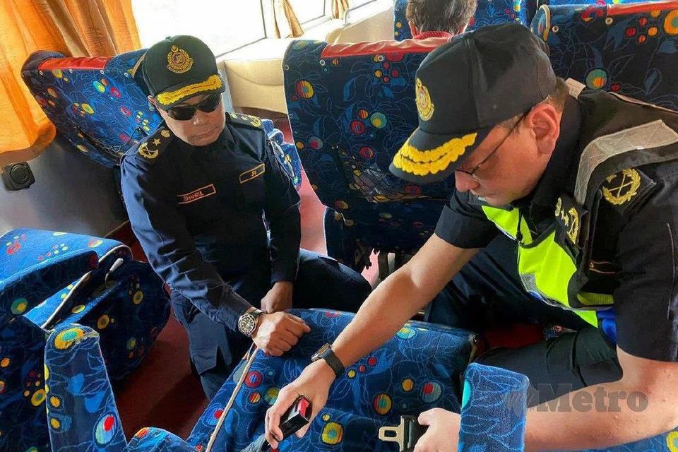 Pengarah JPJ Kedah, Encik Stien Van Lutam (kanan) memeriksa tali pinggang keledar di dalam sebuah bas ekspres yang diperiksa dalam operasi pada 1 Julai 2025.
