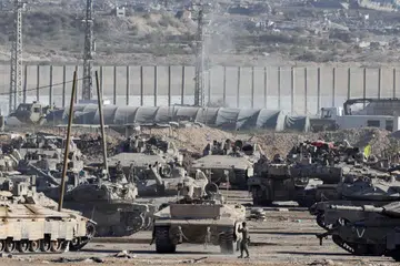 Anggota tentera Israel berdiri berhampiran kenderaan tentera selepas kerajaan Israel meluluskan perjanjian gencatan senjata dengan Hamas di Gaza, di bahagian sempadan Israel-Gaza, Israel, pada 10 Oktober 2025.
