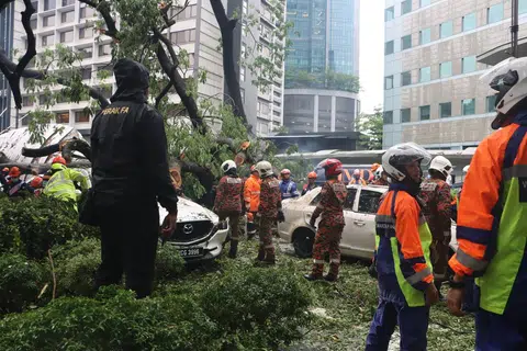 Anggota bomba kelihatan menjalankan operasi selepas sebatang pokok besar tumbang di Jalan Sultan Ismail pada petang 7 Mei.