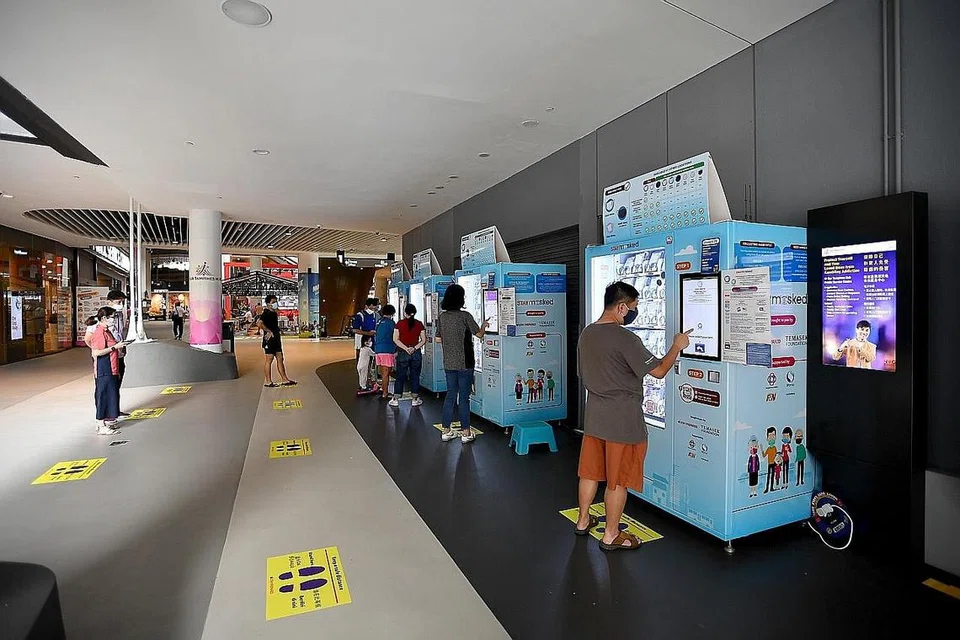 PERCUMA: Penduduk Singapura mula mengambil dua pelitup antimikrob yang boleh digunakan semula semalam, sumbangan Yayasan Temasek. - Foto BH oleh LIM YAOHUI