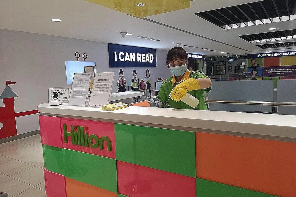 LAKSANAKAN LANGKAH TAMBAHAN: Seorang pekerja di Hillion Mall sedang menyahjangkit dan membersihkan di salah sebuah kaunter perkhidmatan di pusat itu. - Foto HILLION MALL
