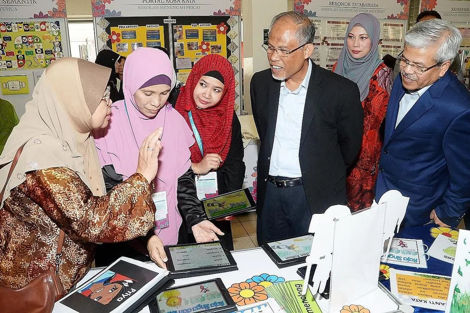 BERTUTUR DENGAN BAIK AGAR MAKNA DAPAT DISAMPAIKAN: Menteri Sekitaran dan Sumber Air, Encik Masagos Zulkifli Masagos Mohamad (tiga dari kanan), bersama (dari kanan) Pengarah Pusat Bahasa Melayu Singapura, Encik Mohamed Noh Daipi; dan Profesor Madya Dr Indirawati Zahid mendengar penjelasan daripada guru dan pensyarah di Seminar Bahasa Melayu 2017. Seminar tahunan tersebut diadakan semalam dan dihadiri sekitar 580 pendidik dan tetamu. - Foto JOHARI RAHMAT