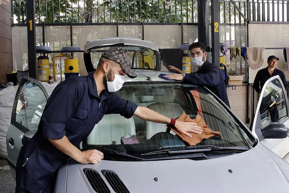 KESAN LONGGARKAN SEKATAN: Pekerja pencuci kenderaan di Tehran, Iran, pada 17 Mei 2020. Iran telah mula mengurangkan sekatan Covid-19 dalam usaha untuk membuka semula ekonomi. Namun beberapa wilayah kini menyaksikan lonjakan jangkitan menyebabkan beberapa bandar terpaksa ditutup semula. - Foto EPA-EFE