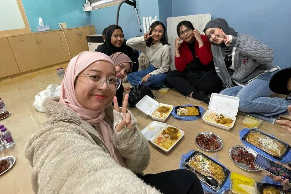Cik Hannah Batrisyia Hamdi (kanan) berbuka puasa di Masjid Seoul Central di Korea Selatan bersama teman-temannya dari Singapura, Malaysia dan Indonesia.  Antara teman-teman barunya itu juga adalah pelajar pertukaran seperti dirinya.