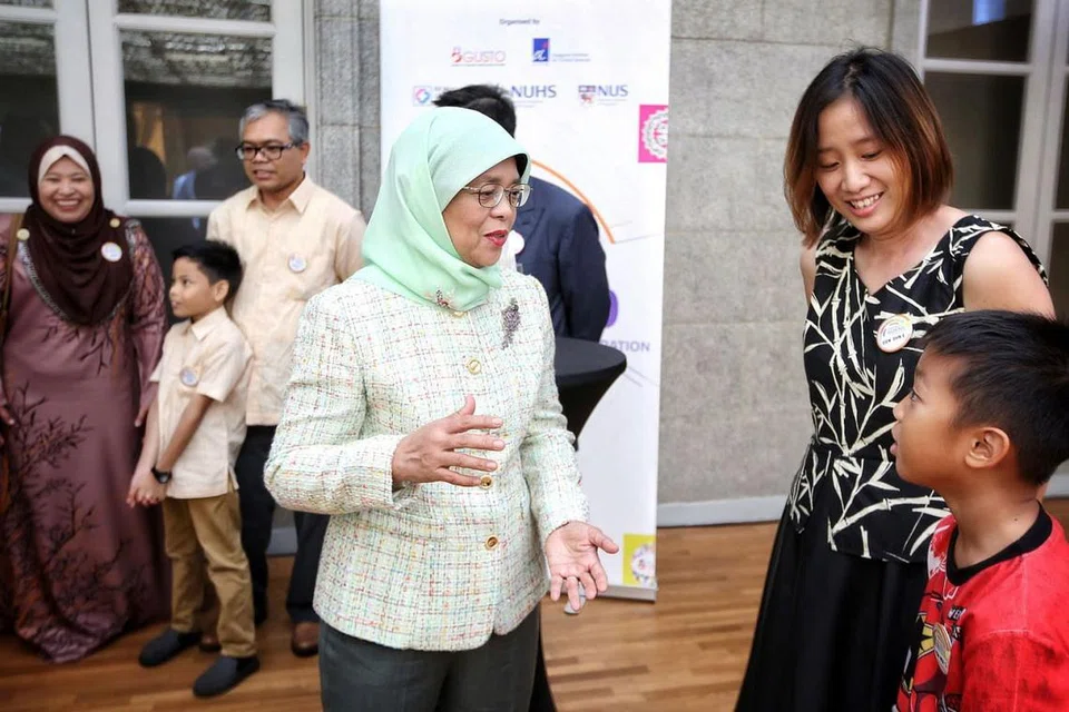 DEMI KEBAIKAN: Presiden Halimah Yacob berinteraksi dengan beberapa keluarga yang telah menyumbang kepada kajian yang dijalankan Gusto. - Foto SPH