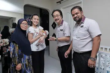 BERSALIN DENGAN SELAMAT: Cik Siti dan Cik Rosnah mengucapkan terima kasih kepada Encik Lim dan Encik Sadick, yang mengunjungi rumah mereka di Simei kelmarin, kerana membantu Cik Siti hingga selamat melahirkan bayinya Muhammad Irfan Nufayl Muhammad Ismail. - Foto BH oleh GAVIN FOO