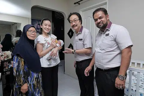 BERSALIN DENGAN SELAMAT: Cik Siti dan Cik Rosnah mengucapkan terima kasih kepada Encik Lim dan Encik Sadick, yang mengunjungi rumah mereka di Simei kelmarin, kerana membantu Cik Siti hingga selamat melahirkan bayinya Muhammad Irfan Nufayl Muhammad Ismail. - Foto BH oleh GAVIN FOO