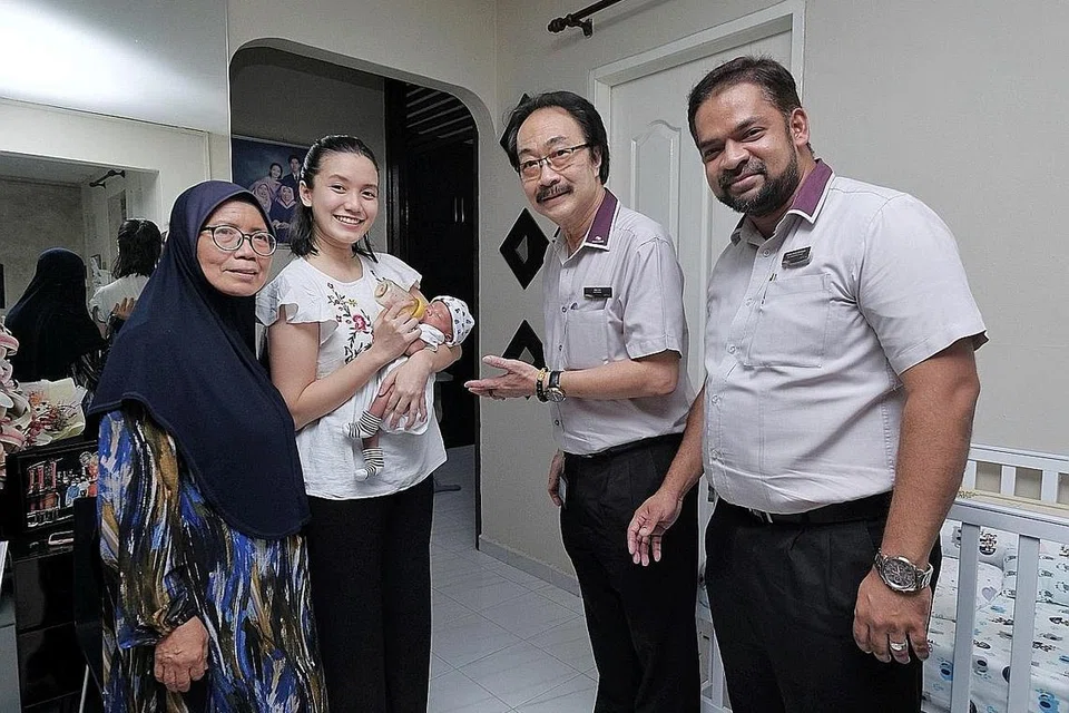 BERSALIN DENGAN SELAMAT: Cik Siti dan Cik Rosnah mengucapkan terima kasih kepada Encik Lim dan Encik Sadick, yang mengunjungi rumah mereka di Simei kelmarin, kerana membantu Cik Siti hingga selamat melahirkan bayinya Muhammad Irfan Nufayl Muhammad Ismail. - Foto BH oleh GAVIN FOO