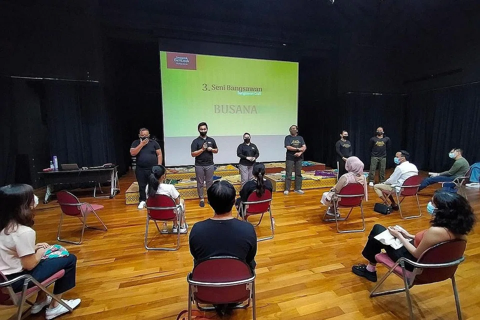 KONGSI ILMU: Penaung Anggerik Temasek Bangsawan, Noor Azhar Mohamed (berdiri dua dari kiri), bersama pelakon bangsawan memberi taklimat tentang pentingnya busana terperinci serta lenggok bangsawan kepada peserta bengkel. - Foto ANGGERIK TEMASEK BANGSAWAN.