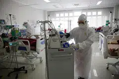 RAWAT PESAKIT: Kakitangan perubatan di Unit Jagaan Rapi (ICU) di Hospital Kota Bogor menjalankan pemeriksaan biasa ke atas pesakit Covid-19 di hospital tersebut pada 23 Jun lalu. - Foto EPA-EFE 