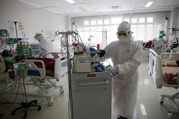 RAWAT PESAKIT: Kakitangan perubatan di Unit Jagaan Rapi (ICU) di Hospital Kota Bogor menjalankan pemeriksaan biasa ke atas pesakit Covid-19 di hospital tersebut pada 23 Jun lalu. - Foto EPA-EFE 