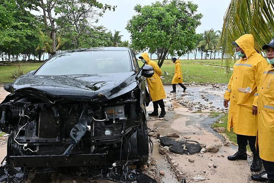 MENYUSULI TSUNAMI: Pegawai keselamatan dalam negara Indonesia memeriksa sebuah kereta yang rosak di Resort Tanjung Lesung Beach di Banten.