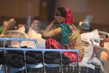KEADAAN MEMILUKAN: Seorang pesakit Covid-19 di India berehat di dewan bankuet yang diubah menjadi wad sementara pesakit Covid-19 kerana ruang hospital yang tidak mencukupi. - Foto AFP/MONEY SHARMA