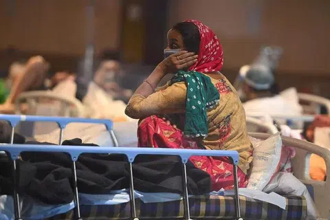 KEADAAN MEMILUKAN: Seorang pesakit Covid-19 di India berehat di dewan bankuet yang diubah menjadi wad sementara pesakit Covid-19 kerana ruang hospital yang tidak mencukupi. - Foto AFP/MONEY SHARMA