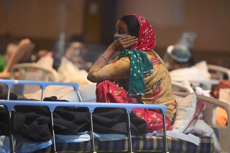 KEADAAN MEMILUKAN: Seorang pesakit Covid-19 di India berehat di dewan bankuet yang diubah menjadi wad sementara pesakit Covid-19 kerana ruang hospital yang tidak mencukupi. - Foto AFP/MONEY SHARMA
