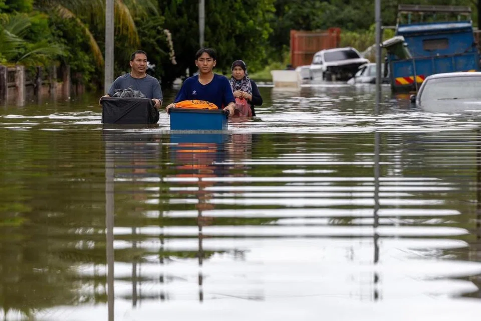 Penduduk di sebuah kawasan di Sarawak meredah banjir untuk berpindah ke pusat pemindahan sementara (PPS).