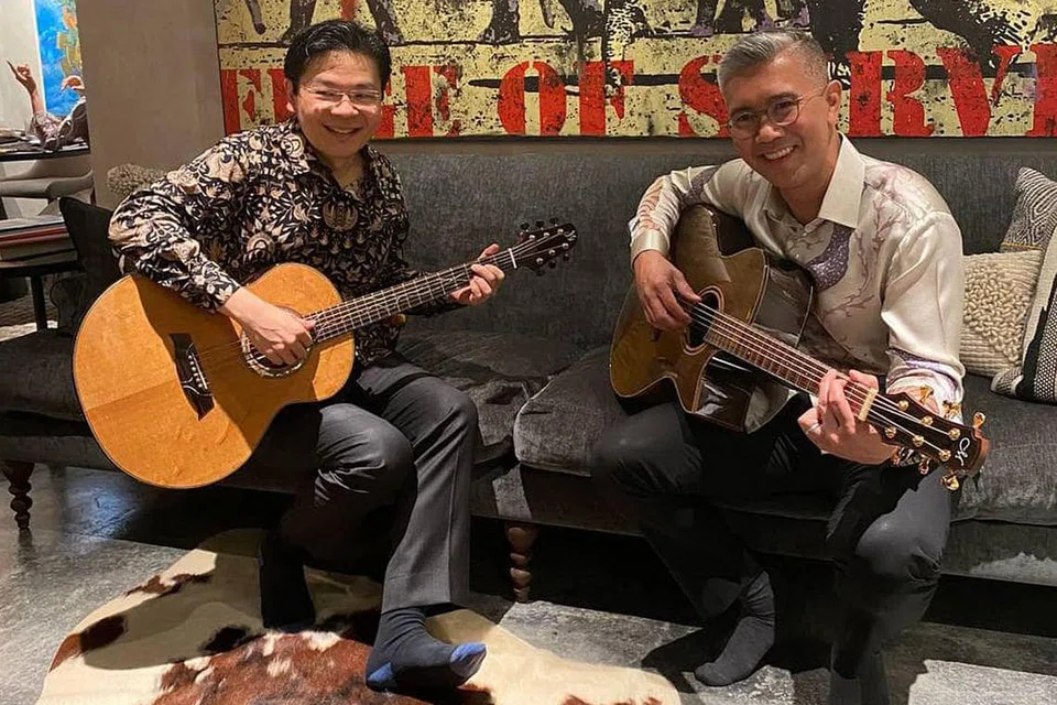 DIPLOMASI GITAR: Encik Wong (kiri) bermain gitar bersama Tengku Zafrul semasa pertemuan mereka kelmarin.