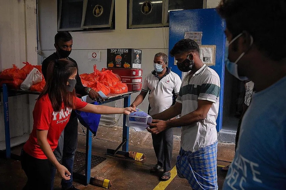SUMBANG BANTUAN: Sukarelawan YMCA Singapura memberikan nota tulisan sendiri serta bungkusan makanan kepada pekerja asing terjejas dek keadaan Covid-19. - Foto BH oleh MARK CHEONG