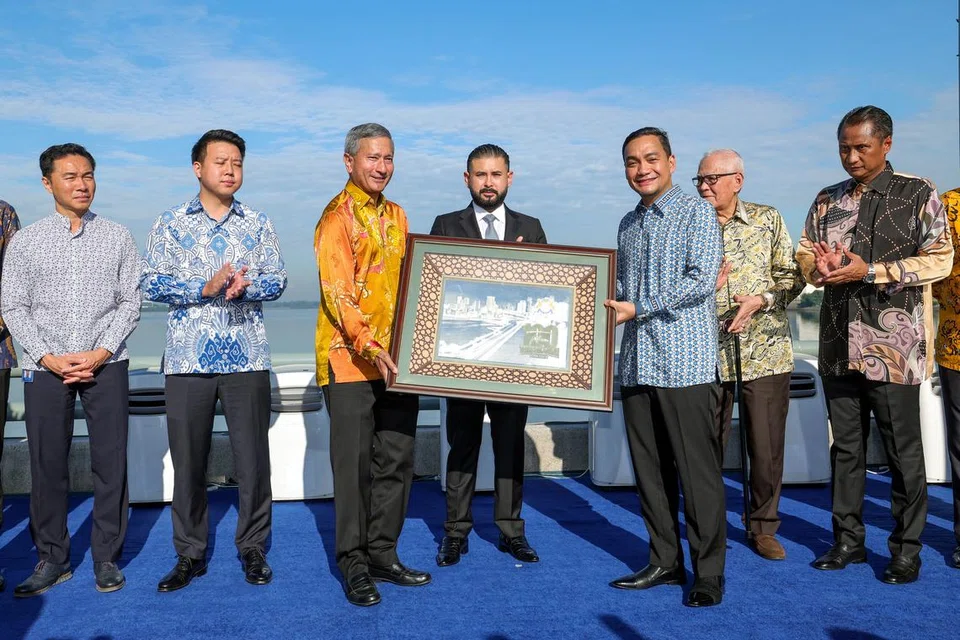 Pemangku Sultan Johor Tunku Mahkota Ismail (tengah) berkenan menyaksikan penyerahan cenderahati daripada Menteri Besar Johor Datuk Onn Hafiz Ghazi (tiga dari kanan) kepada Menteri Ehwal Luar Singapura, Dr Vivian Balakrishnan (tiga dari kiri) pada Sambutan 100 Tahun Tambak Johor di tengah tambak sempadan Johor dan Singapura pada 28 Jun.