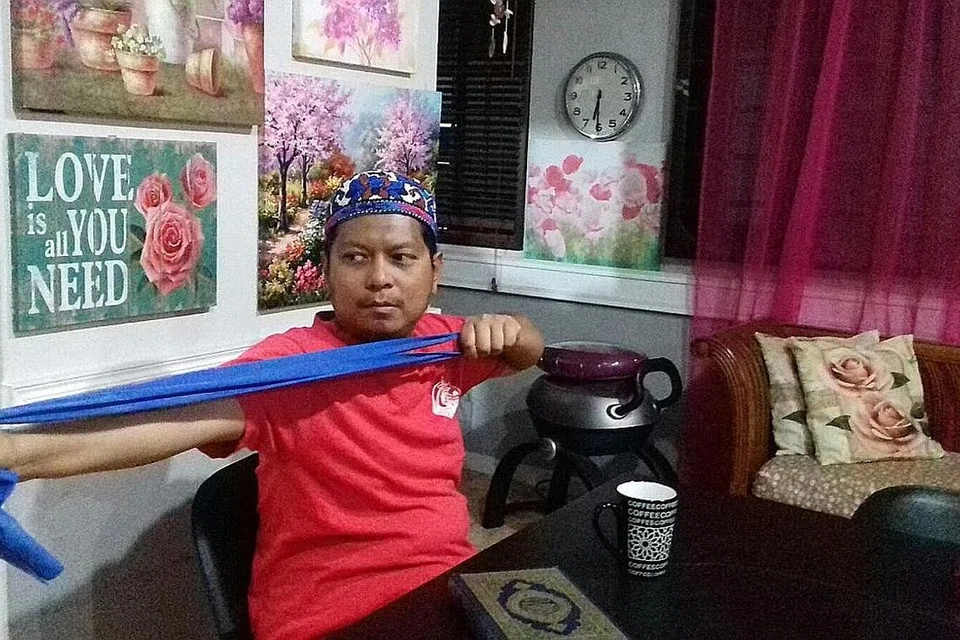 SENAMAN HARIAN: Selepas membaca Al-Quran setiap pagi, Ustaz Fachruddin Dzaki akan meluangkan masa sekurang-kurangnya setengah jam menarik sejenis getah senaman untuk memperkuat otot lengan, bahu dan belakangnya. Ini akan menambah kekuatannya menarik busur panah selain salah satu bentuk senaman yang diamalkan untuk menjaga kesihatannya. - Foto ihsan USTAZ FACHRUDDIN DZAKI dan fail