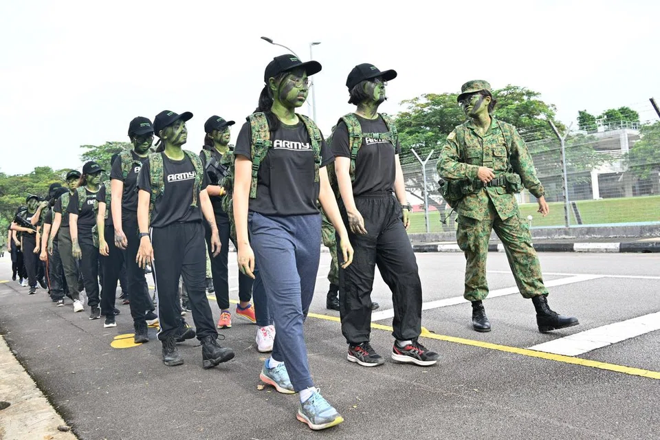 AWAL PAGI: Peserta memulakan hari ketiga mereka dengan berjalan kaki sekitar Kem Maju sepanjang dua kilometer, acara simulasi kegiatan ‘route march’ yang kerap dilakukan anggota Angkatan Bersenjata Singapura (SAF). Dengan wajah yang diselaputi warna celoreng dan memikul beg berisi ‘field pack’, mereka dapat menghayati kehidupan anggota SAF dengan lebih mendalam.