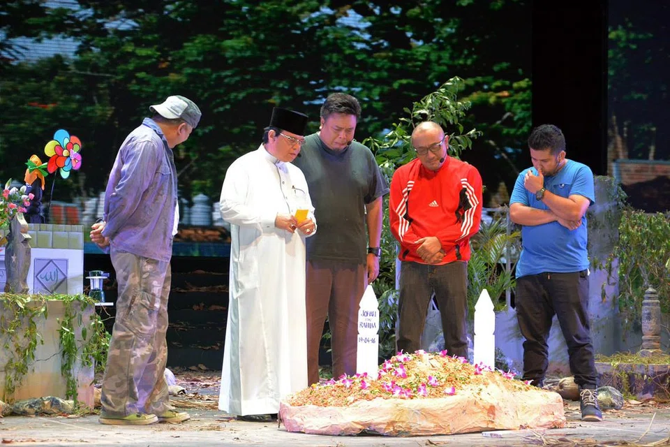 ADAB PENGEBUMIAN: Ustaz Ahmad Dahri (dua dari kiri) memberi penerangan tentang pentingnya menjaga kelakuan di perkuburan. Watak-watak lain termasuk (dari kiri) Husin Saaban, Suhaimi Yusof, Khairudin Samsuddin dan Isa, ahli kumpulan Maharaja Lawak BORA. - Foto JAMIYAH SINGAPURA