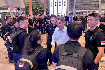 SEDIA HULUR BANTUAN: Dr Faishal (tengah) beramah dengan anggota pasukan respons awal SCDF di lapangan terbang Changi sebelum mereka berlepas. Turut bersama beliau ialah Pesuruhjaya SCDF, Komander Eric Yap (di kanan Dr Faishal), dan ketua kontinjen, LTC Lok Wee Keong (paling kanan). - Foto SCDF
