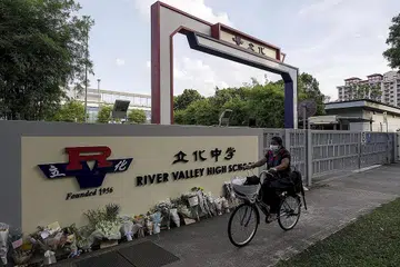 BUAT KENANGAN: Jambangan bunga diletak di pintu masuk Sekolah Tinggi River Valley selepas kejadian seorang pelajar 13 tahun disyaki dibunuh oleh seorang pelajar lebih tua pada 19 Julai lalu. - Foto fail