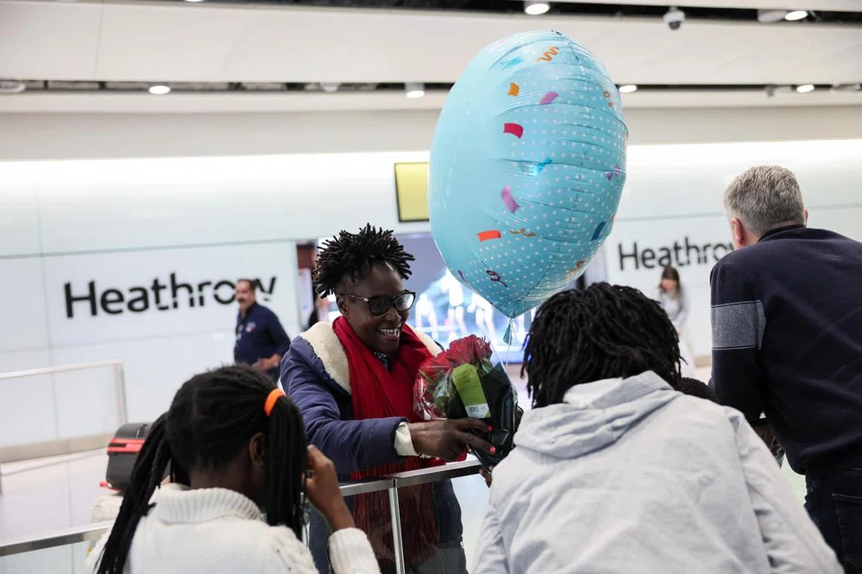 Seorang wanita dilihat memegang sejambak bunga dan belon di Terminal 2 Lapangan Terbang Antarabangsa Heathrow, sehari selepas kebakaran di sebuah pencawang elektrik berhampiran menyebabkan gangguan bekalan kuasa di lapangan terbang itu, berhampiran London, Britain, pada 22 Mac 2025.