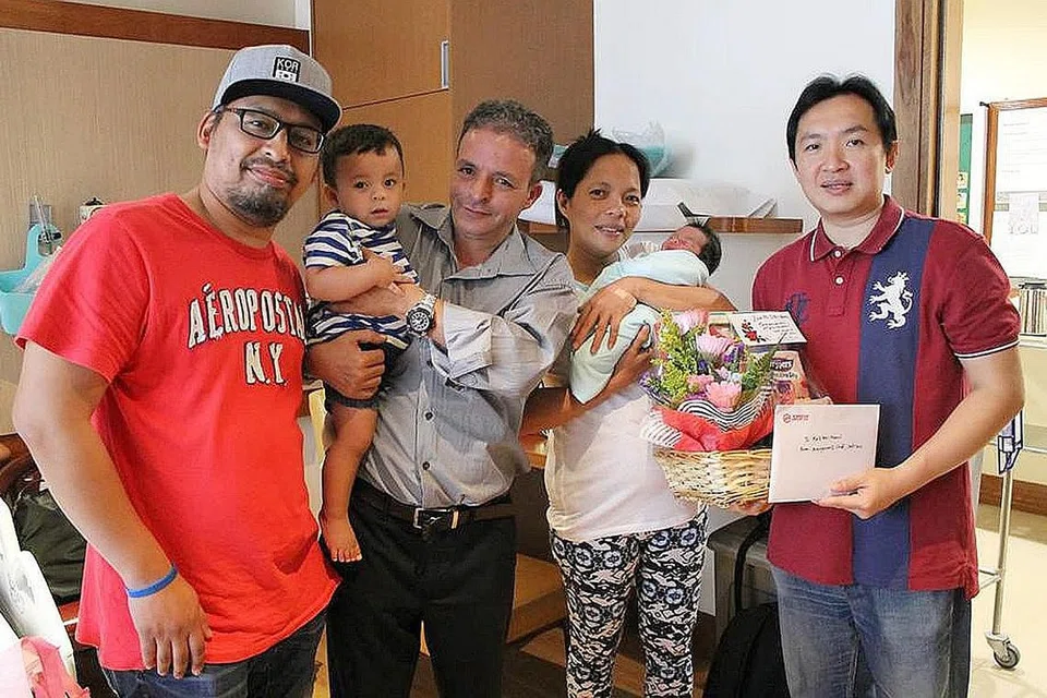 BERSALIN DALAM TEKSI: Encik Nazraruddin (bertopi) telah membantu pasangan Encik Hamid (berbaju kelabu) dan Cik Maria Elena semasa kelahiran anak mereka. Bersama mereka ialah kedua-dua anak pasangan itu dan seorang wakil SMRT. - Foto FACEBOOK SMRT