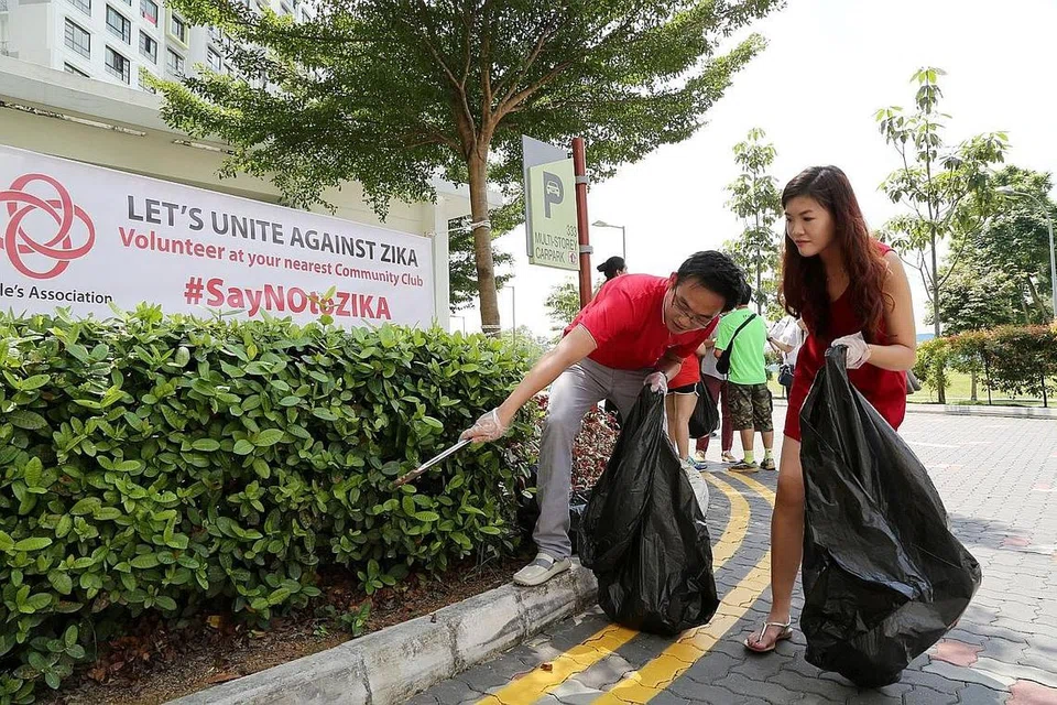 TURUN PADANG: Penduduk sama-sama menyertai usaha membasmi tapak pembiakan nyamuk di Yishun Street 31 semalam. - Foto PERSATUAN RAKYAT