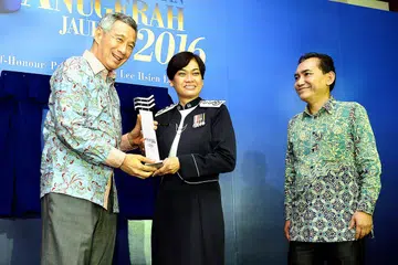 JAUHARI 2016: Cik Zuraidah Abdullah menerima Anugerah Jauhari 2016 daripada Perdana Menteri Lee Hsien Loong dengan diperhatikan oleh Editor Berita Harian/Minggu, Encik Saat Abdul Rahman. - Foto M.O. SALLEH