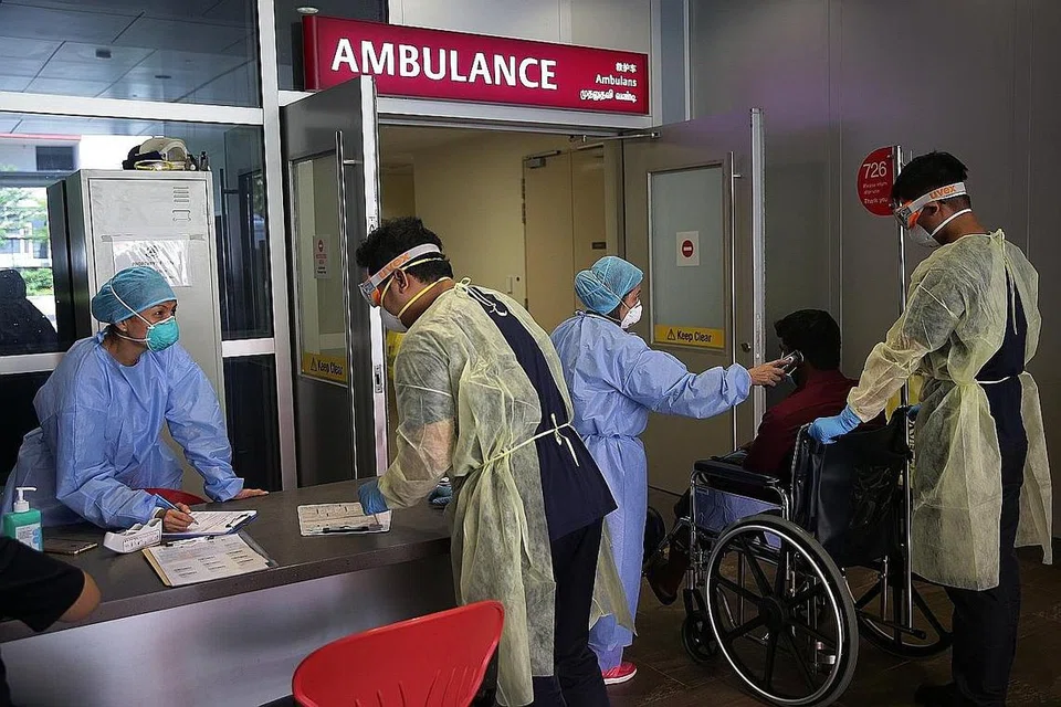 BERTUGAS: Pekerja penjagaan kesihatan kelihatan memberi khidmat kepada seorang pesakit di Hospital Besar Ng Teng Fong. - Foto fail