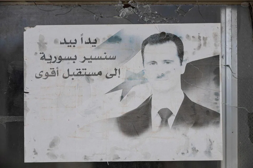 Sebuah potret mantan Presiden Syria Bashar al-Assad menghiasi berek Divisyen Keempat tentera Syria di bandar Dummar berhampiran Damsyik, pada 23 Disember.