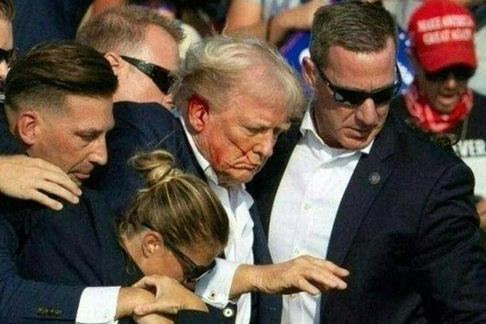 Calon presiden Republikan, Encik Donald Trump (tengah), yang ditembak semasa satu acara kempen, segera dibawa turun dari pentas oleh Perkhidmatan Risik Amerika Syarikat di Pennsylvania.  