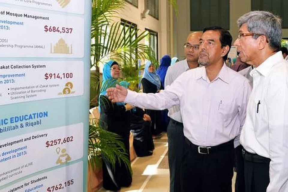 PELAN TAHUN-TAHUN MENDATANG: Dr Yaacob (kanan) diberi taklimat mengenai pencapaian tahun lalu dan rancangan Muis tahun ini oleh Haji Abdul Razak di Seminar Pelan Kerja Muis semalam.
