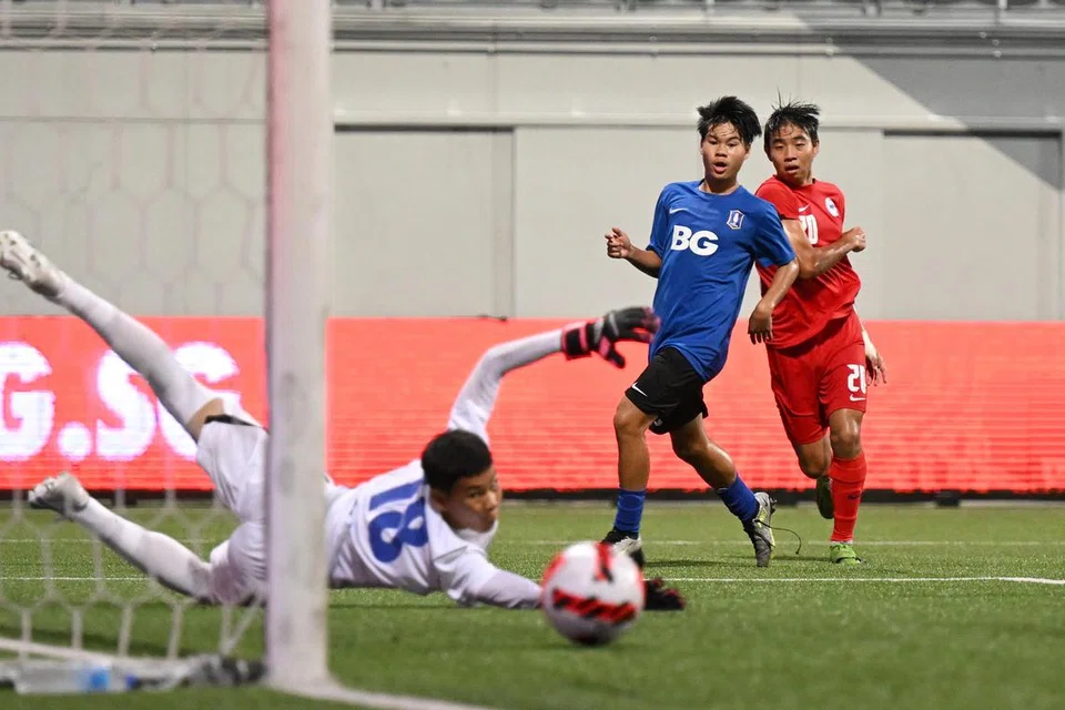 TIDAK MASUK GAWANG: Nathan Mao (jersi merah) melihat sepakannya melewati gawang dalam perlawanan akhir Piala Lion City menentang BG Pathum. Skuad bola sepak lelaki bawah 15 tahun Singapura tewas 3-4 melalui sepakan penalti.