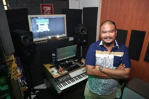 MUZIK WADAH DEKATI BAKAT BARU: Encik Ghazali Sawi, yang mesra dengan panggilan Abang Bobb, membangun studio Guzzbuzz Productions yang menyediakan khidmat mengadun dan menyusun semula lagu, gembira dapat berkongsi ilmu dengan bakat muda. - Foto BH oleh TIMOTHY DAVID